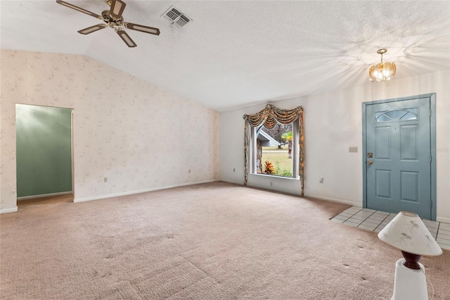 interior space featuring carpet, a textured ceiling, ceiling fan with notable chandelier, and vaulted ceiling