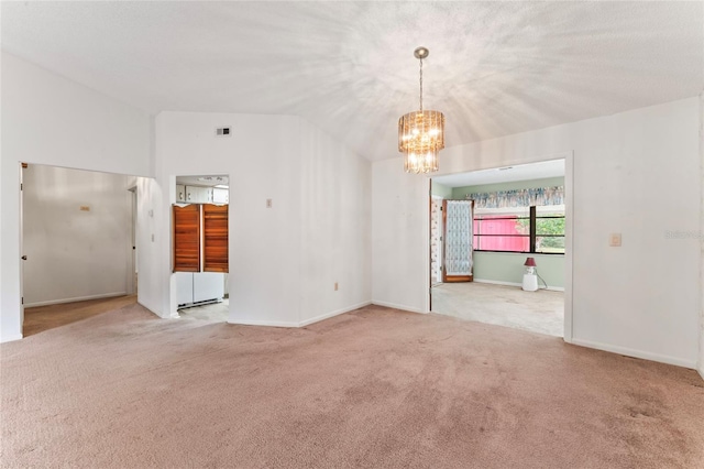 spare room with light colored carpet, lofted ceiling, and a chandelier