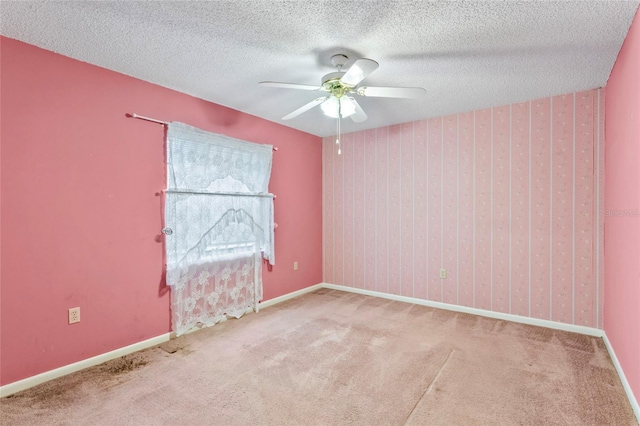 carpeted spare room with ceiling fan and a textured ceiling