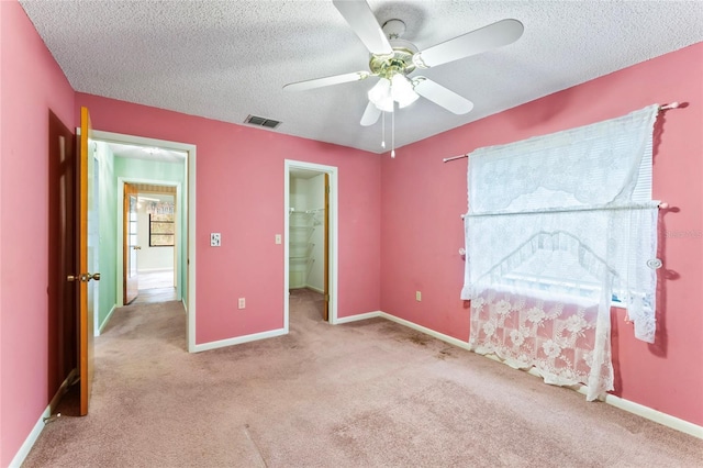 carpeted bedroom featuring ceiling fan, ensuite bathroom, and a textured ceiling