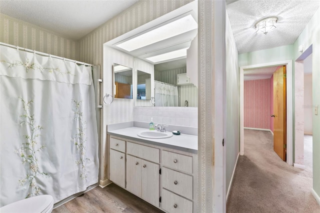 bathroom featuring vanity, hardwood / wood-style floors, and a textured ceiling