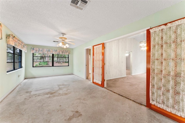 spare room with a textured ceiling and ceiling fan with notable chandelier