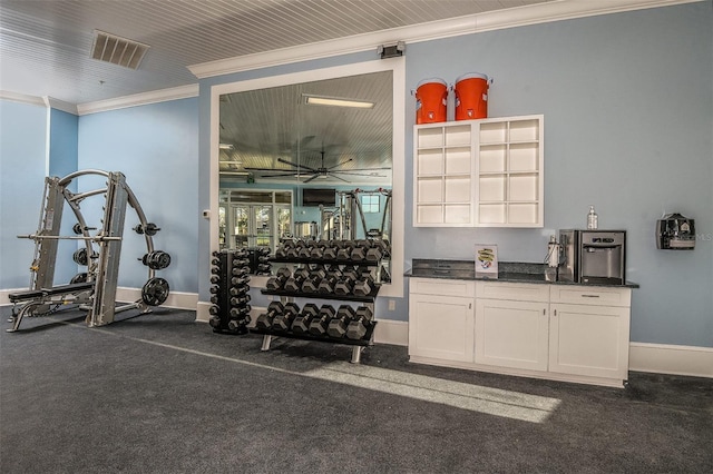 workout area with crown molding, ceiling fan, and dark colored carpet