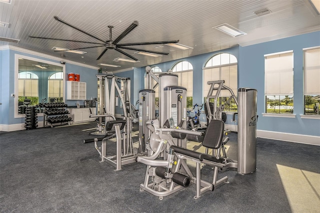 workout area featuring ceiling fan and ornamental molding