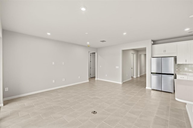 unfurnished living room featuring recessed lighting and baseboards