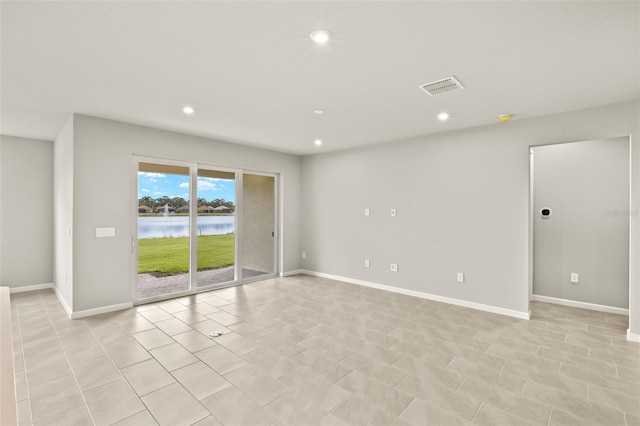 empty room with a water view, recessed lighting, and baseboards