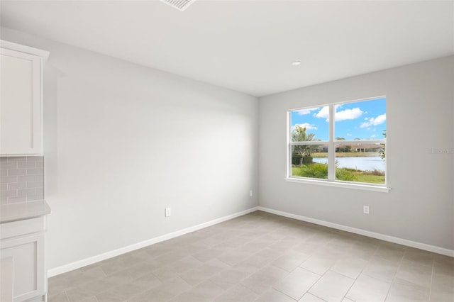 empty room with a water view and baseboards