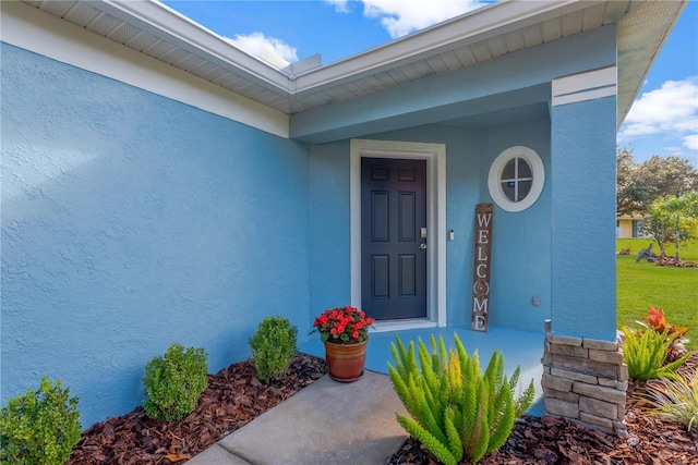 entrance to property with a lawn