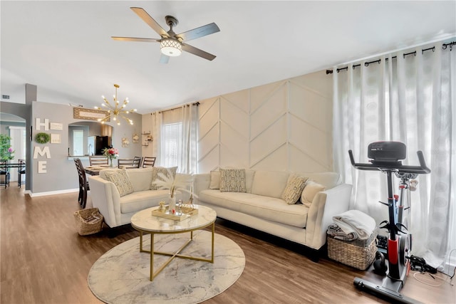 living room featuring wood-type flooring and ceiling fan with notable chandelier