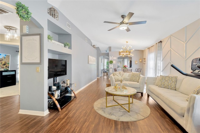 living room featuring a wealth of natural light, ceiling fan with notable chandelier, and hardwood / wood-style flooring