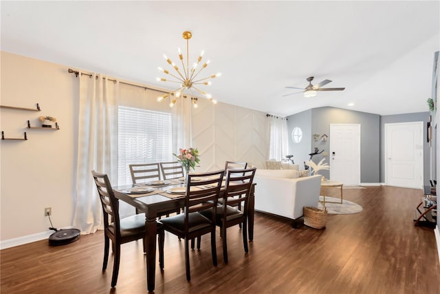 dining room with a wealth of natural light, ceiling fan with notable chandelier, dark wood-type flooring, and vaulted ceiling