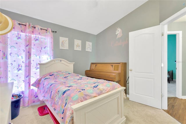 bedroom featuring light colored carpet and lofted ceiling