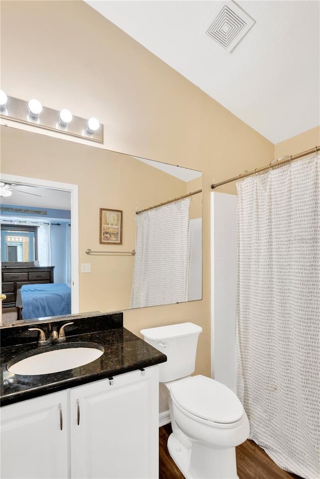 bathroom featuring vanity, ceiling fan, toilet, walk in shower, and wood-type flooring