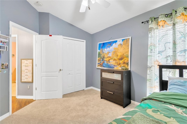 carpeted bedroom featuring ceiling fan, vaulted ceiling, and a closet