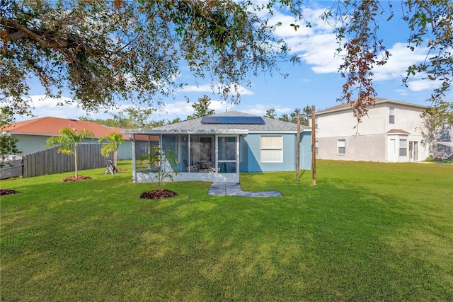 back of house with a lawn, solar panels, and a sunroom