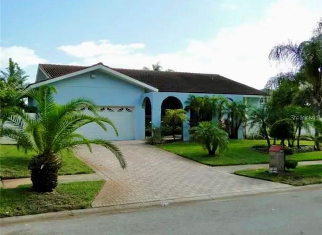 view of front of house with a garage and a front lawn