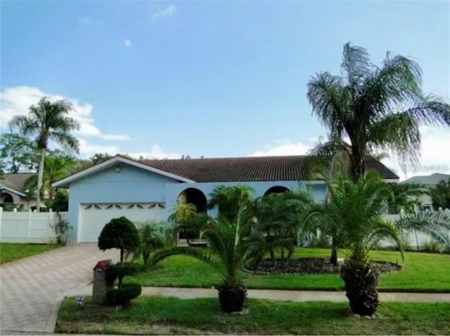 view of front of property with a garage and a front lawn