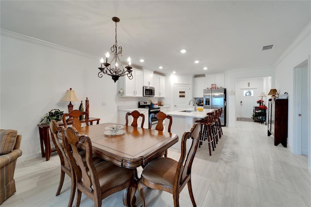 dining room featuring sink, an inviting chandelier, and crown molding