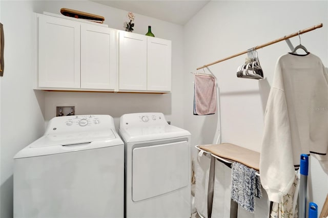 laundry room with washing machine and clothes dryer and cabinets