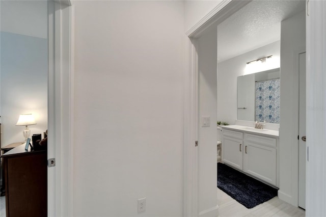 bathroom with a shower with shower curtain, vanity, and a textured ceiling