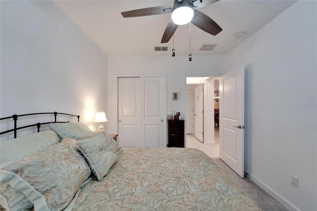 bedroom with ceiling fan, a closet, and light carpet