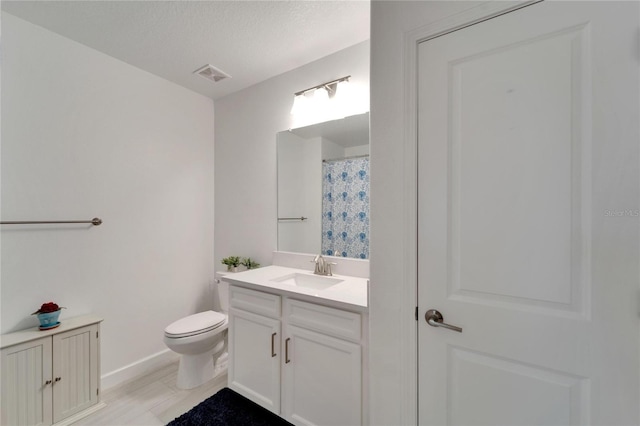 bathroom with toilet, vanity, and a textured ceiling