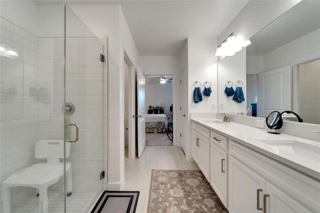 bathroom featuring ceiling fan, walk in shower, and vanity