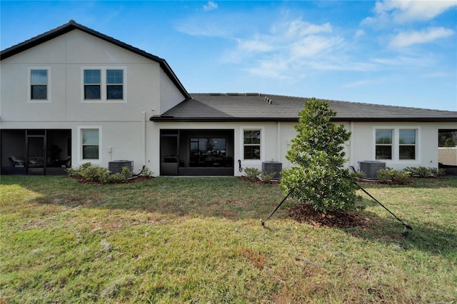 back of property featuring cooling unit, a yard, and a sunroom