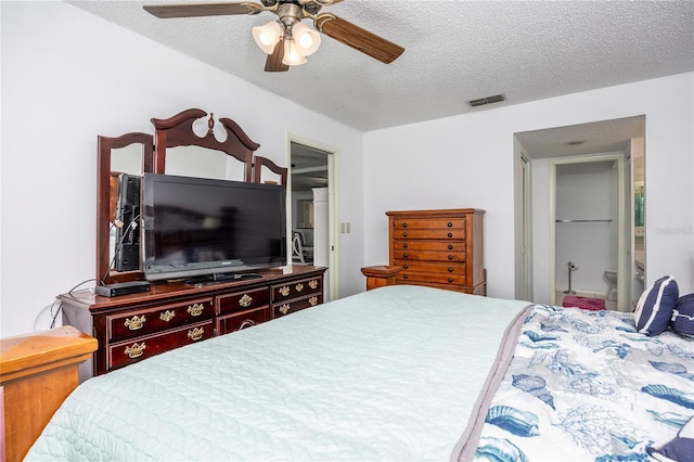 bedroom featuring ceiling fan, a textured ceiling, and ensuite bath