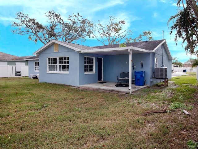 back of property featuring a lawn, central AC, and a patio area