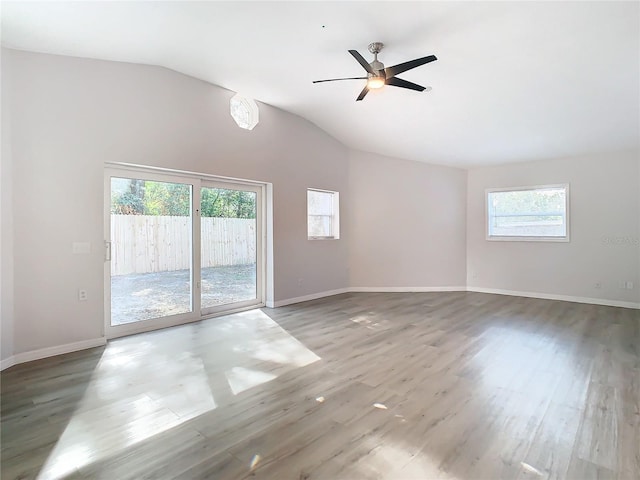 spare room with hardwood / wood-style flooring, ceiling fan, lofted ceiling, and a wealth of natural light