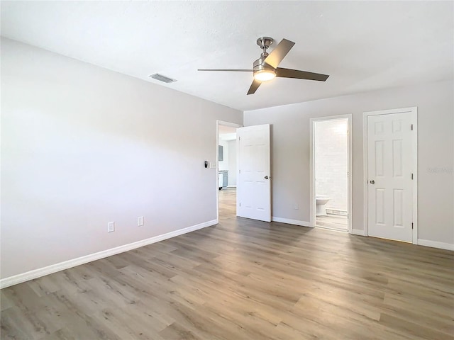 unfurnished bedroom featuring ceiling fan, ensuite bathroom, and wood-type flooring