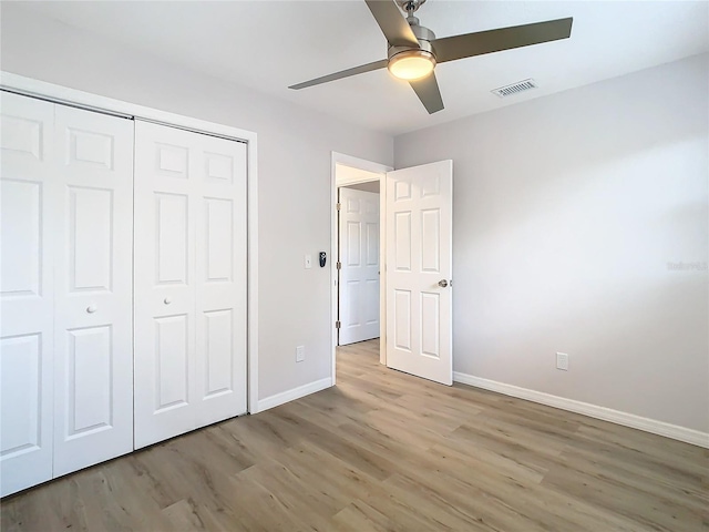 unfurnished bedroom with ceiling fan, light wood-type flooring, and a closet