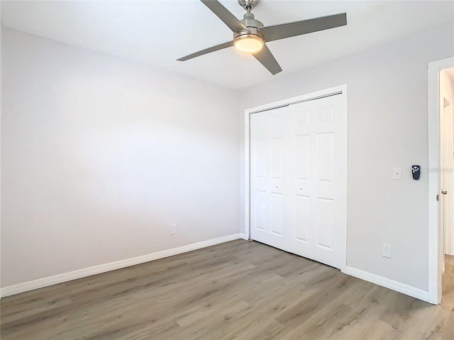 unfurnished bedroom with hardwood / wood-style floors, a closet, and ceiling fan