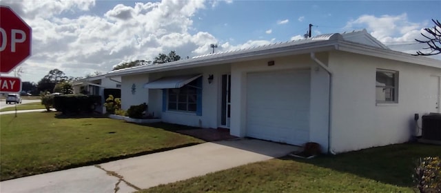 view of side of home with stucco siding, central air condition unit, a lawn, an attached garage, and driveway