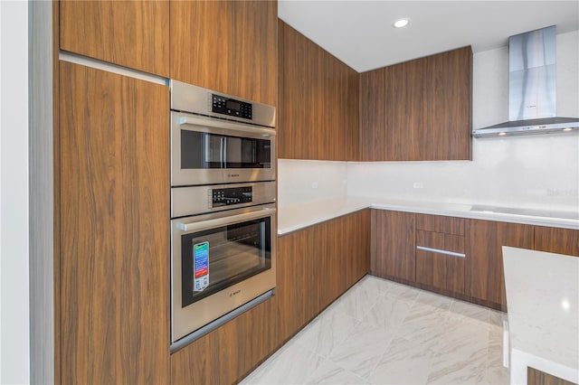 kitchen featuring cooktop, stainless steel double oven, and wall chimney exhaust hood