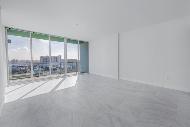 spare room with plenty of natural light and a wall of windows