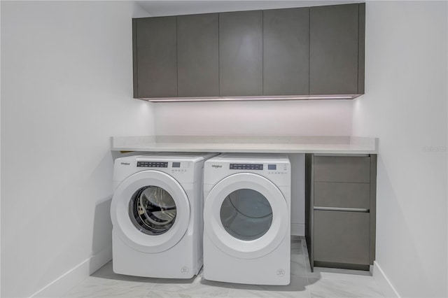 laundry area with washer and dryer and cabinets