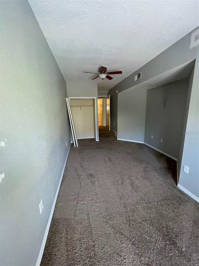 carpeted spare room featuring ceiling fan and a textured ceiling