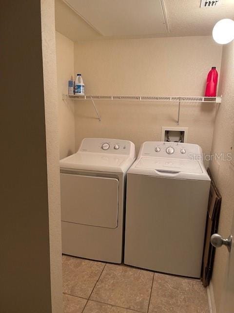 washroom featuring light tile patterned floors and washer and dryer