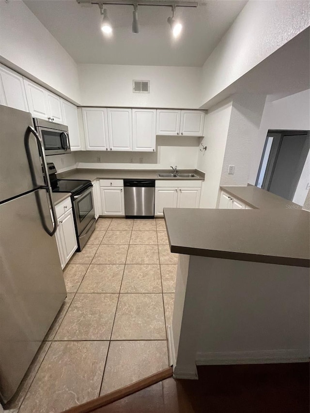 kitchen with sink, white cabinetry, kitchen peninsula, and appliances with stainless steel finishes