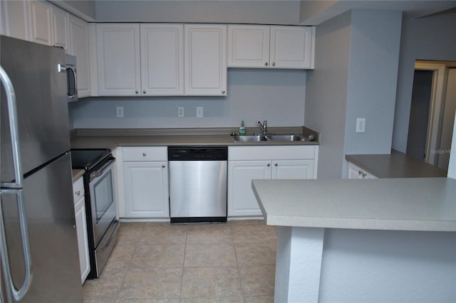 kitchen with sink, light tile patterned floors, appliances with stainless steel finishes, white cabinetry, and kitchen peninsula