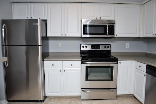 kitchen with light tile patterned floors, stainless steel appliances, and white cabinetry