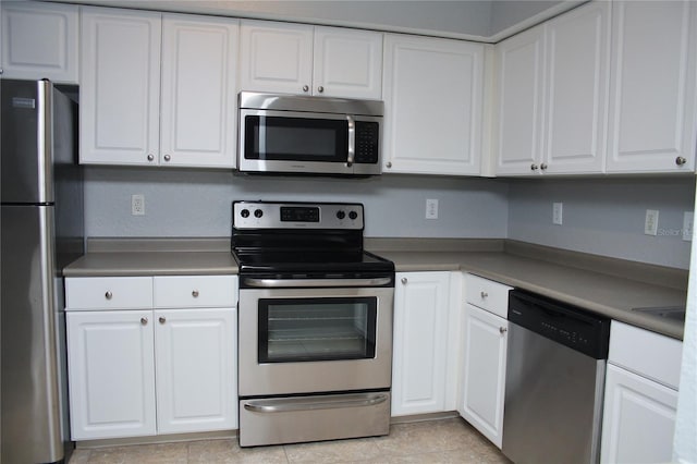 kitchen featuring white cabinets, light tile patterned floors, and stainless steel appliances