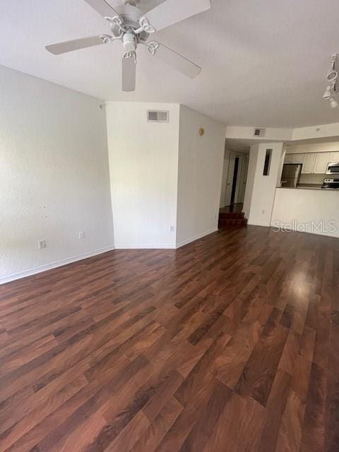 unfurnished living room featuring ceiling fan and dark wood-type flooring