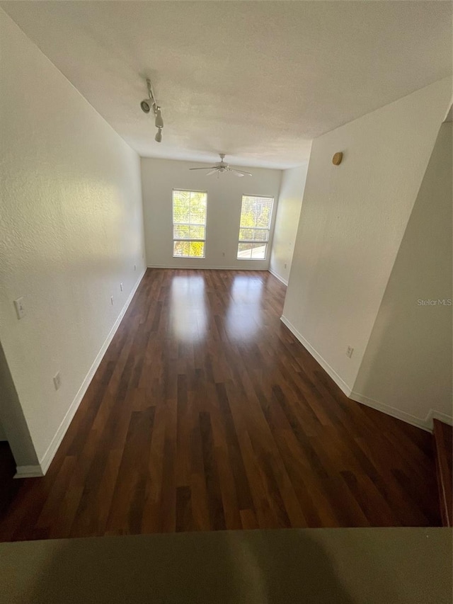 unfurnished room featuring ceiling fan, dark hardwood / wood-style flooring, and track lighting