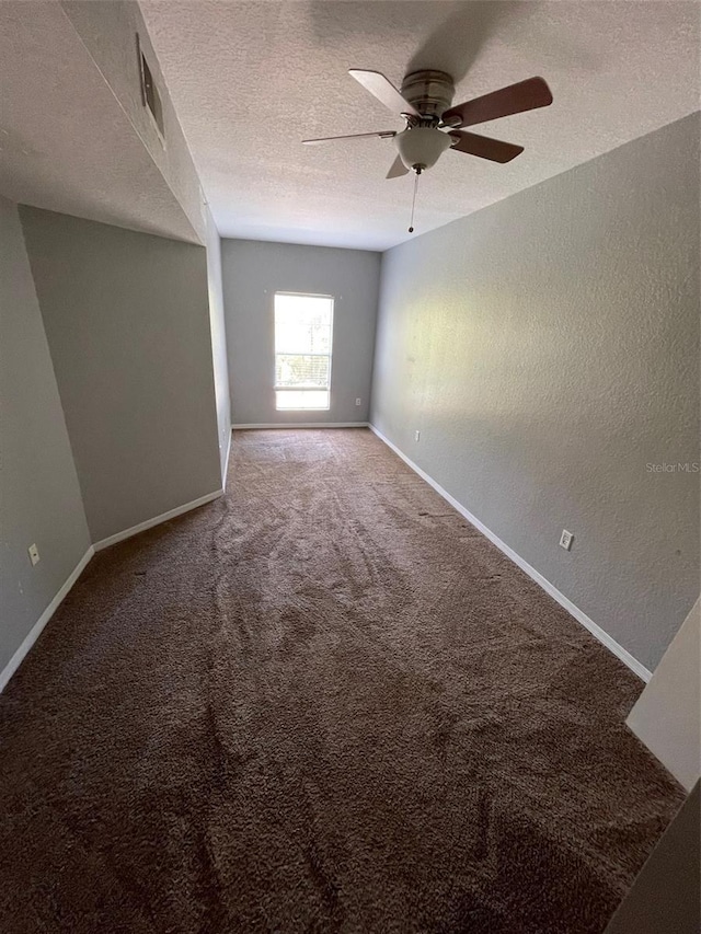 carpeted spare room with ceiling fan and a textured ceiling