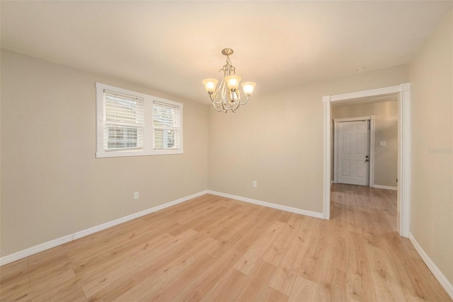 unfurnished room featuring a chandelier and light hardwood / wood-style floors