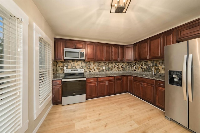 kitchen featuring decorative backsplash, sink, stainless steel appliances, and light hardwood / wood-style floors