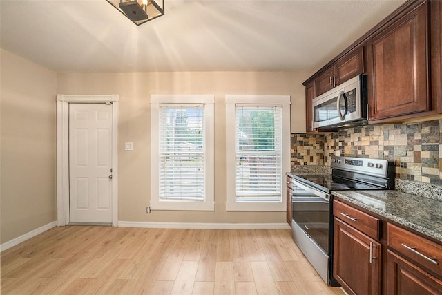 kitchen featuring decorative backsplash, stainless steel appliances, and light wood-type flooring